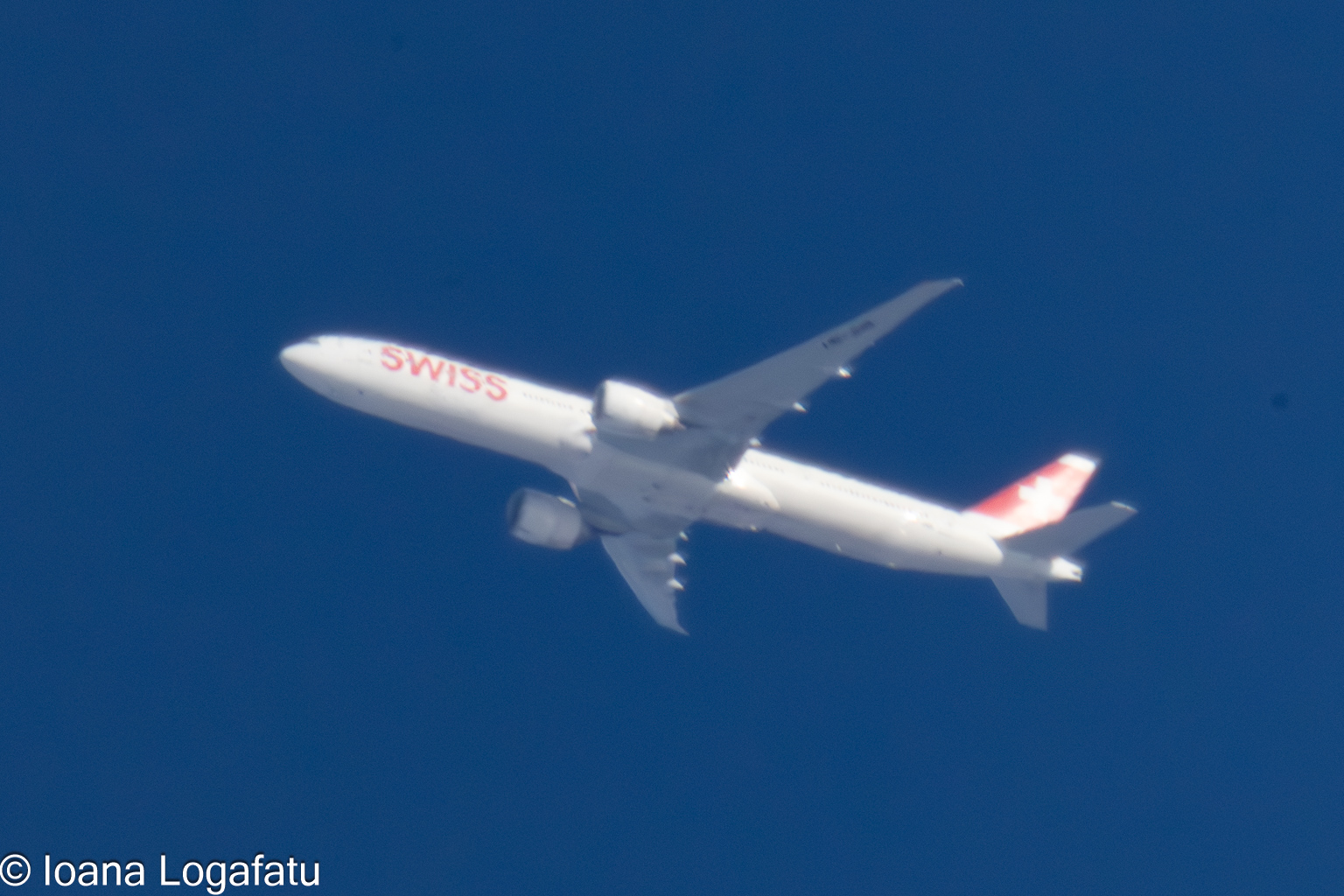 Bright airplane gliding through a clear blue sky